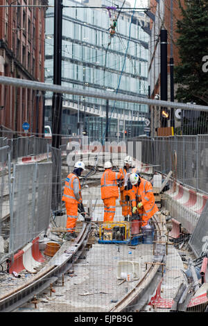 Workmen working on the Tram lines in Manchester's city center Stock Photo