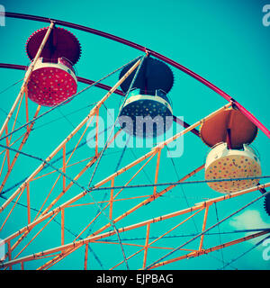 closeup of a colorful vintage Ferris wheel over the blue sky, with a retro effect Stock Photo