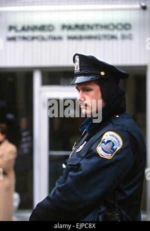 A Washington police officer stands guard at the Planned Parenthood clinic following threats during the annual Anti-Abortion protest January 22, 1997 in Washington, DC. Stock Photo