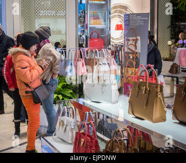 Shoppers browse Michael Kors leather goods in the Macy's Herald Square flagship store in New York on Sunday, March 22, 2015 (© Richard B. Levine) Stock Photo