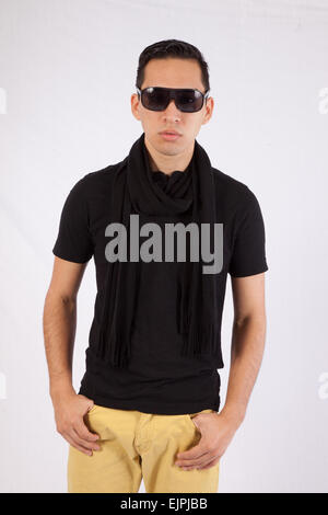 Young man in black shirt and sunglasses, looking thoughtfully at the camera Stock Photo