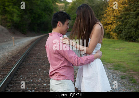 Romantic Asian couple playing outside being affectionate and smiling Stock Photo