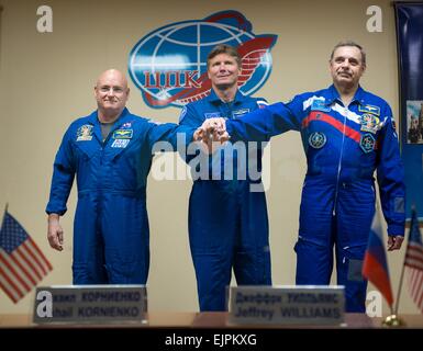 International Space Station Expedition 43 Commander NASA Astronaut Scott Kelly, left, with Russian cosmonauts Gennady Padalka, center, and Mikhail Kornienko behind the quarantine glass during a crew press conference at the Cosmonaut Hotel March 26, 2015 in Baikonur, Kazakhstan. Kelly and cosmonauts Mikhail Kornienko and Gennady Padalka launch in their Soyuz TMA-16M spacecraft on March 28 for a year long mission onboard the ISS. Stock Photo