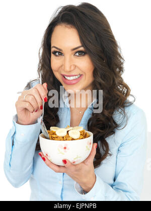 Attractive Young Woman Eating Breakfast Cereals with Banana Stock Photo
