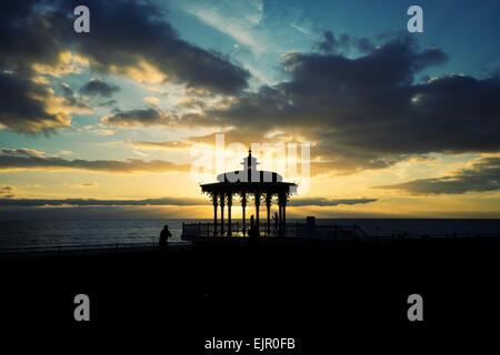 This was taken on Brighton seafront at dusk on Christmas Eve 2014, it shows a man taking a photo of a woman in a small pavilion Stock Photo