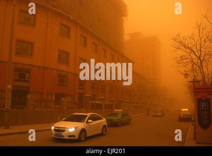 Dunhuang, China's Gansu Province. 31st Mar, 2015. Motorcars run amid sandstorm on a street in Dunhuang City, northwest China's Gansu Province, March 31, 2015. A sandstorm hit Dunhuang on Tuesday, affecting local traffic and farming. Credit:  Zhang Xiaoliang/Xinhua/Alamy Live News Stock Photo