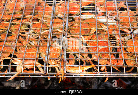 Grilled crab on flaming grill. Charcoal fire grill. Barbecue embers glowing in red fire. Stock Photo