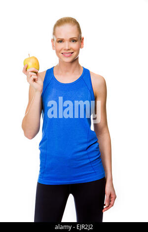 blonde smiling woman wearing fitness clothing and holding an apple Stock Photo