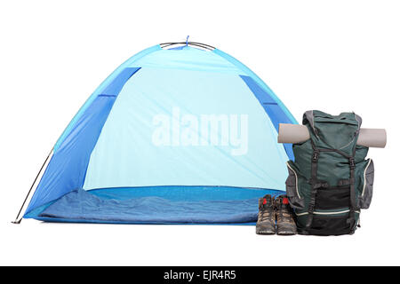 Frontal shot of blue tent, a rucksack with hiking equipment and a pair of boots isolated on white background Stock Photo