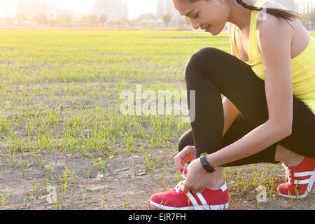 Young woman tying shoelace Stock Photo