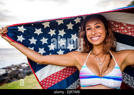 Woman standing under American flag quilt Stock Photo