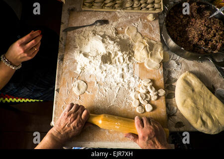 High angle view of family rolling pastry dough at kitchen table Stock Photo