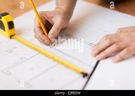 close up of male hands making changes to blueprint Stock Photo