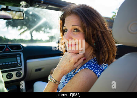 Older Caucasian woman riding in convertible Stock Photo