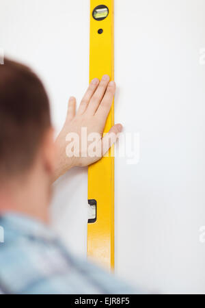 close up of male with spirit level mesuring wall Stock Photo