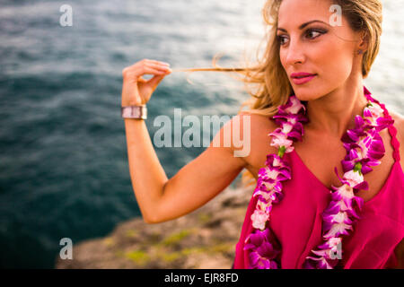 Caucasian woman relaxing on rocks at beach Stock Photo