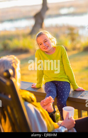 Caucasian grandmother and granddaughter relaxing on porch Stock Photo