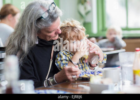 Caucasian grandmother and grandson eating dinner in restaurant Stock Photo
