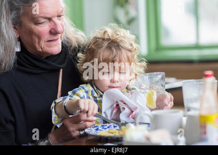 Caucasian grandmother and grandson eating dinner in restaurant Stock Photo