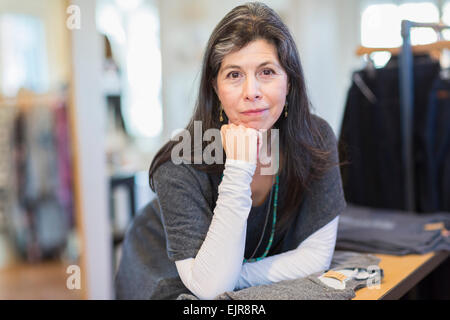 Hispanic small business owner smiling in store Stock Photo