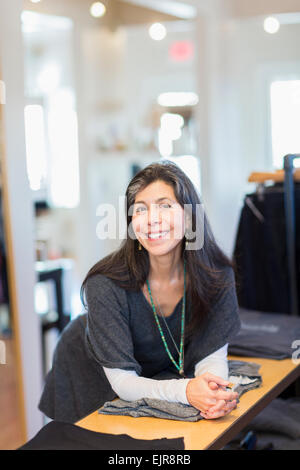 Hispanic small business owner smiling in store Stock Photo