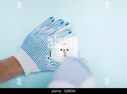 close up of male in gloves installing new socket Stock Photo