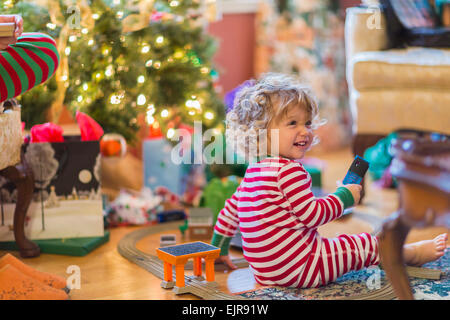 Caucasian baby boy opening presents near Christmas tree Stock Photo