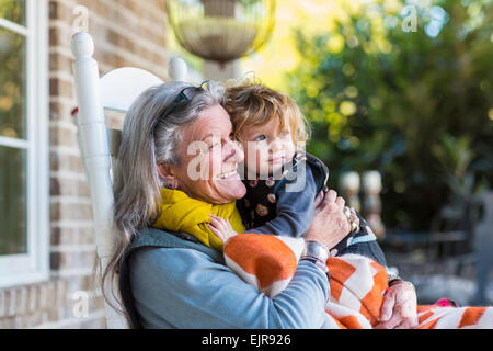 Caucasian grandmother and grandson sitting on porch Stock Photo
