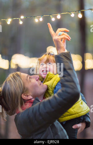 Caucasian mother and son admiring string lights