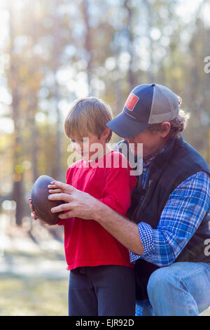 Caucasian father teaching son to play football Stock Photo