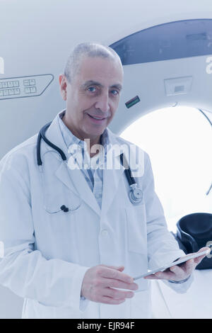 Hispanic doctor using digital tablet near MRI scanner Stock Photo