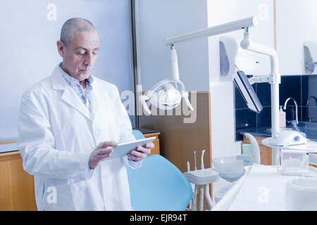 Hispanic dentist using digital tablet in office Stock Photo