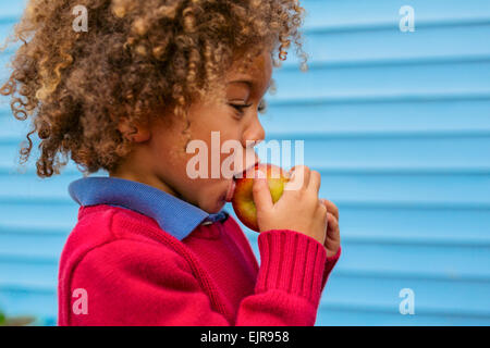 Pacific Islander boy eating apple outdoors Stock Photo