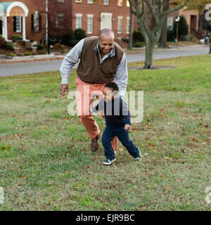 African American father and son playing in park Stock Photo