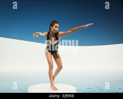 Mixed race woman on ice floe throwing discus Stock Photo