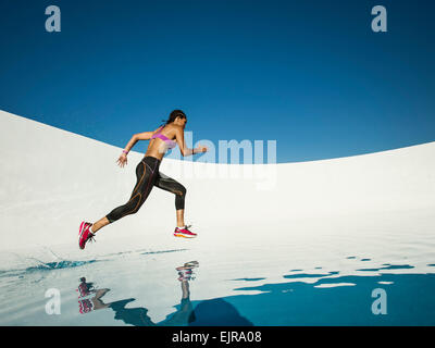 Mixed race woman running on water surface Stock Photo