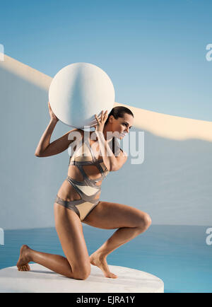 Caucasian woman holding sphere on ice floe Stock Photo