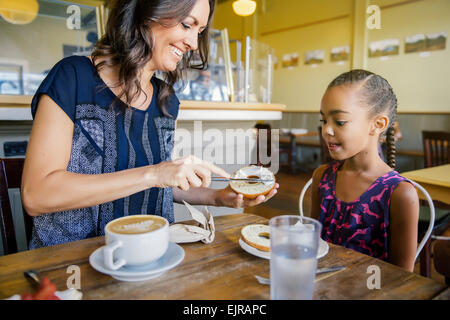 Mother and daughter eating breakfast in cafe Stock Photo