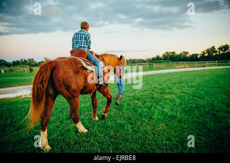 Caucasian mother and son walking horse on ranch Stock Photo