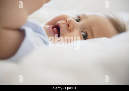 Close up of mixed race baby laying on bed Stock Photo