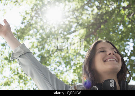 Low angle view of Caucasian woman cheering outdoors Stock Photo