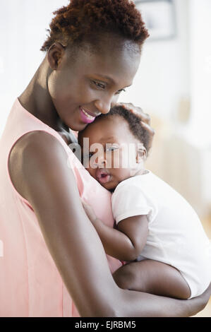 Black mother holding sleepy son