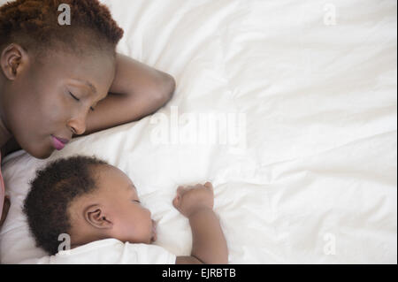 Black mother and son sleeping on bed Stock Photo