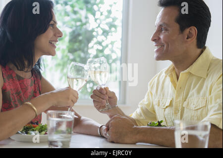 Couple toasting each other with white wine in restaurant Stock Photo