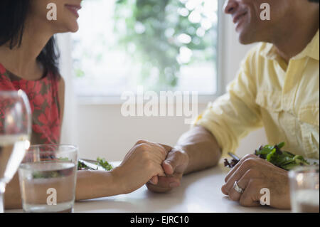 Couple holding hands in restaurant Stock Photo