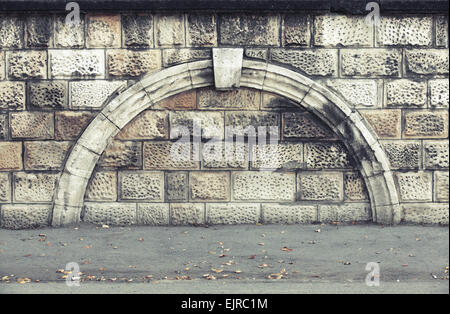 Stone wall with decorative arch, vintage architecture background texture with old style toned filter effect Stock Photo