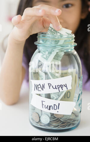 Vietnamese girl saving money in new puppy fund Stock Photo