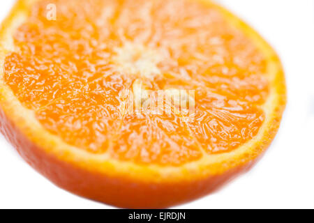 A sliced juicy fresh orange with pips and segments showing on a plain white background in a studio environment Stock Photo