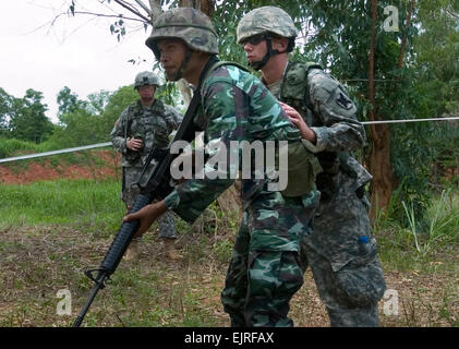 KORAT, THAILAND May 10, 2008-Pfc. Justin Faulk instructs a Soldier in Royal Thai Army proper firing techniques during a reflexive fire range as part of Exercise Cobra Gold 2008. Cobra Gold is a regularly scheduled combined, joint multinational exercise designed to improve U.S, Thai, Singaporean, Japanese, and Indonesian military readiness and combined, joint mutual cooperation, enhance security relationships and demonstrate U.S. resolve to support the security and humanitarian interests of our Pacific partners. This year marks the 27th anniversary of this regional training event. Official U.S  Stock Photo