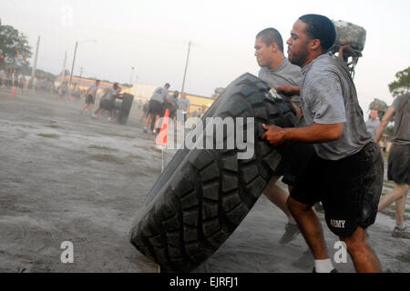 A team of Soldiers with 1st Battalion, 41st Field Artillery Regiment, 1st Heavy Brigade Combat Team, struggle to flip a Hemmitt tire from one row of cones to another during a 40-minute CrossFit competition held by the battalion Aug. 19.  Spc. Emily Knitter, 1/3 HBCT Stock Photo